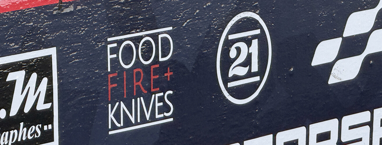 The Food Fire + Knives logo on the pit wall.